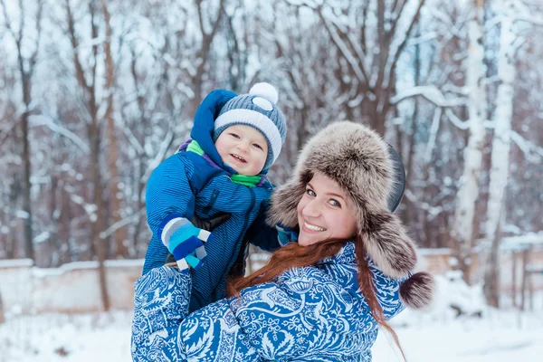 Happy mother and baby playing on snow — Stock Photo, Image
