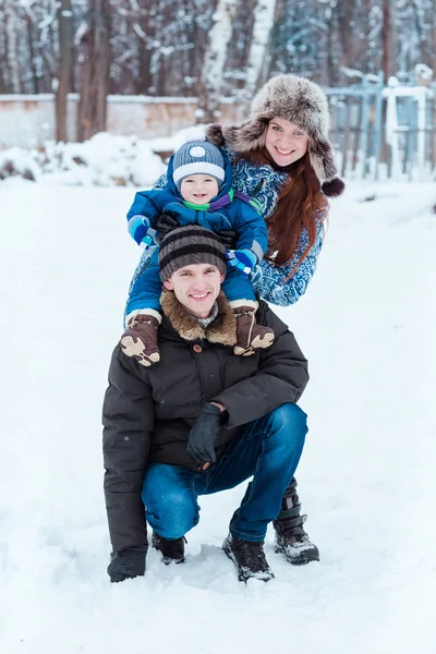 Família feliz jogando na neve — Fotografia de Stock