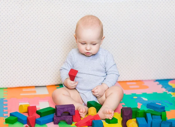 Niedliches kleines Baby spielt mit buntem Spielzeug — Stockfoto