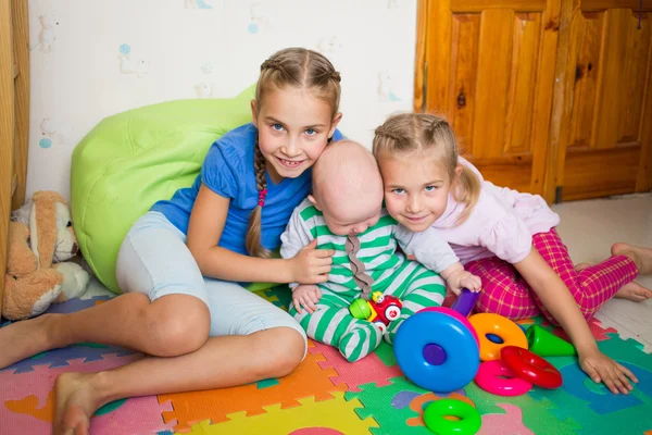 Gelukkige jonge geitjes spelen met kleine broertje — Stockfoto