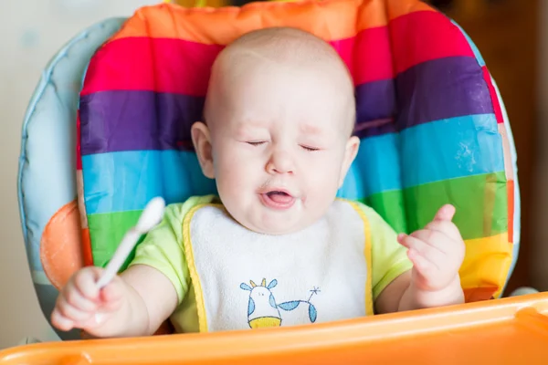 Adorável bebê comendo em cadeira alta — Fotografia de Stock