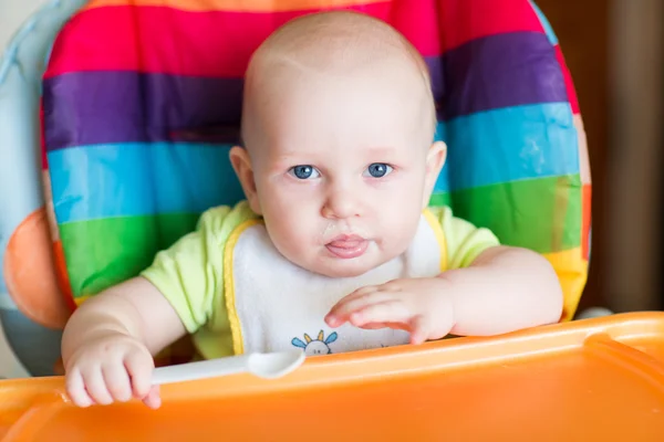 Adorable baby eating in high chair — Stock Photo, Image