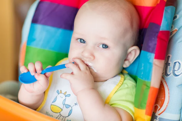 Schattige baby eten in hoge stoel — Stockfoto