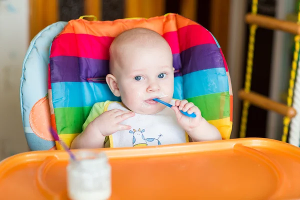 Entzückendes Baby isst im Hochstuhl — Stockfoto