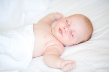 Bir yatakta uyuyan yalan huzurlu yeni doğan bebek