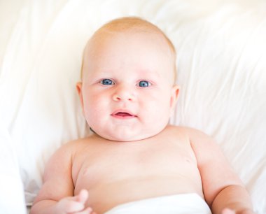 Bir yatakta yatarken huzurlu yeni doğan bebek