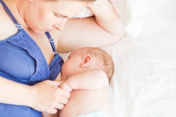 Счастливая мать кормит младенца грудью — стоковое фото
