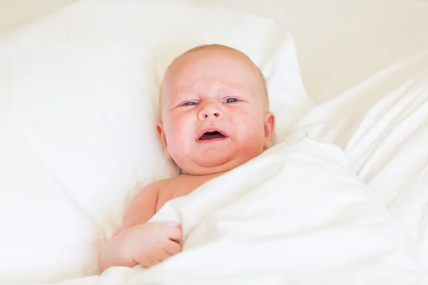 Friedliches Neugeborenes liegt schlafend auf einem Bett — Stockfoto