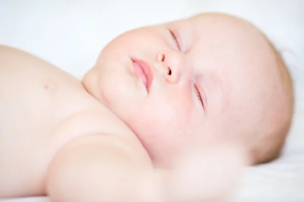 Vreedzame pasgeboren baby liggend op een bed slapen — Stockfoto