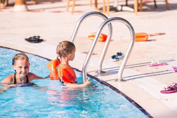 Two cute little girls in swimming pool — Stock Photo, Image