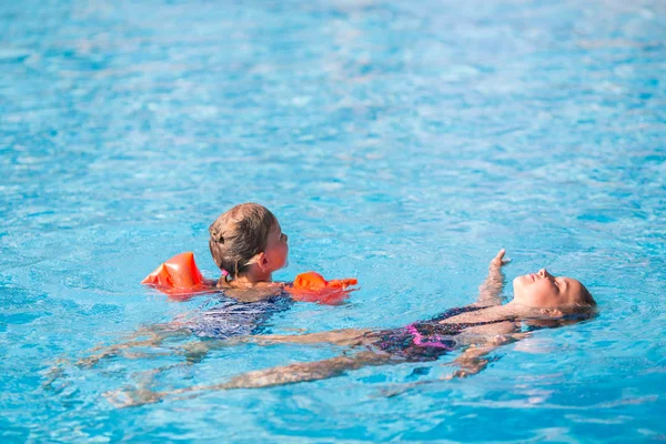 Две милые девочки в бассейне — стоковое фото