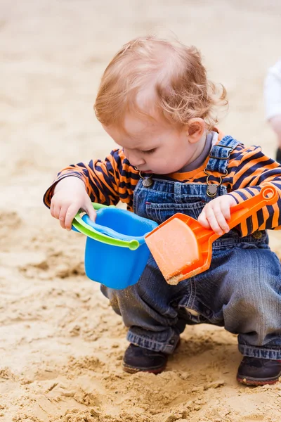 Cute baby boy playing with sand — Stock Photo, Image