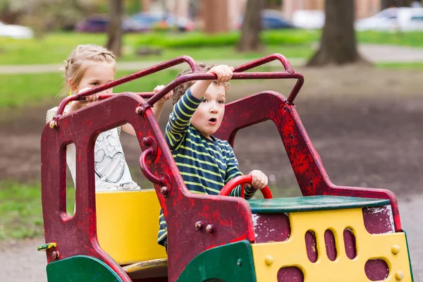 Emocionados niños felices conduciendo un coche de juguete — Foto de Stock