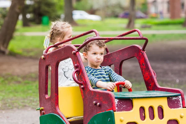 Emocionados niños felices conduciendo un coche de juguete —  Fotos de Stock