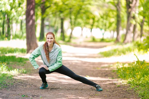 公園でストレッチ フィットの陽気な女性 — ストック写真