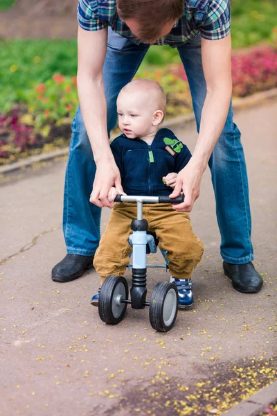 Pai ensinando bebê menino em sua primeira bicicleta de corrida — Fotografia de Stock