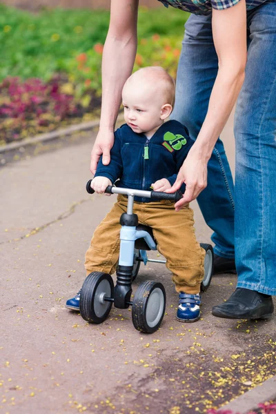 彼の最初のランニング バイクで男の子の赤ちゃんを教える父 — ストック写真