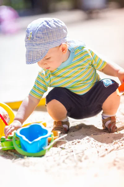 Cute baby boy playing with sand — Stock Photo, Image