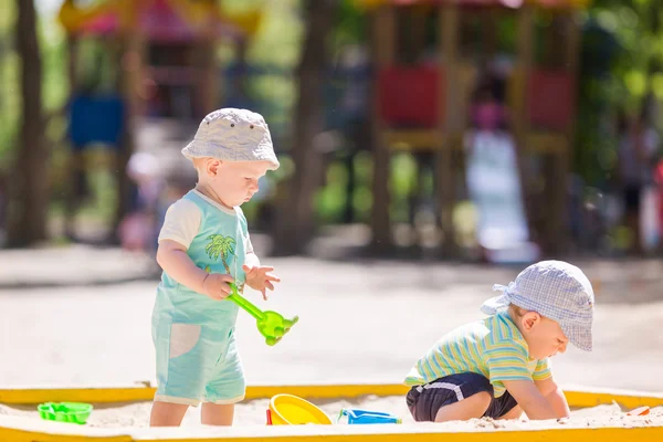 砂で遊ぶ 2 つの赤ちゃん男の子たち — ストック写真