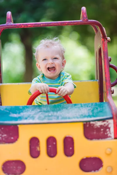 Menino dirigindo um carro de brinquedo no playground — Fotografia de Stock