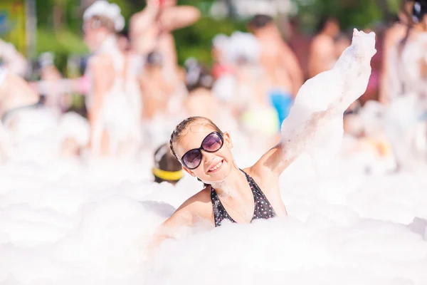 Cute little girl having fun at foam party. — Stock Photo, Image