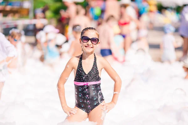 Cute little girl having fun at foam party. — Stock Photo, Image