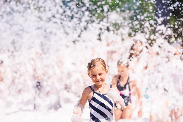 Cute little girl having fun at foam party. 로열티 프리 스톡 사진