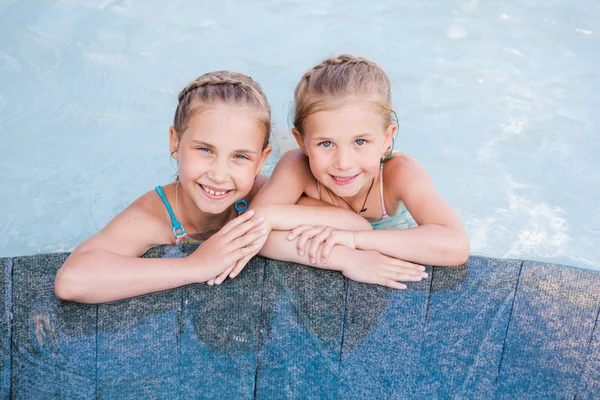 Dvě roztomilé holčičky v bazénu — Stock fotografie