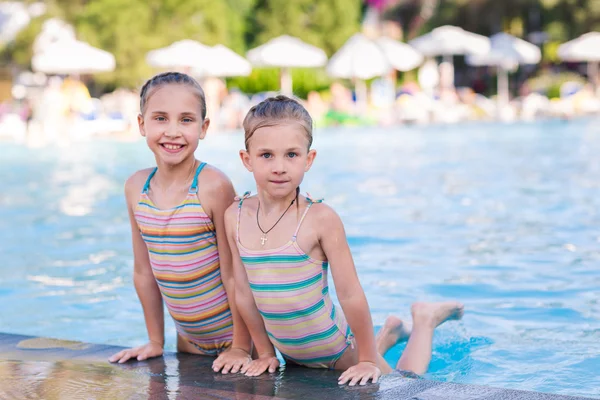 Twee schattige kleine meisjes in zwembad — Stockfoto