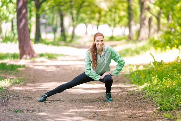 公園でストレッチ フィットの陽気な女性 — ストック写真