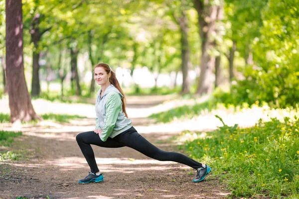 公園でストレッチ フィットの陽気な女性 — ストック写真