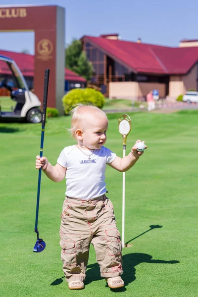 Cute little baby boy playing golf on a field — Stock Photo, Image