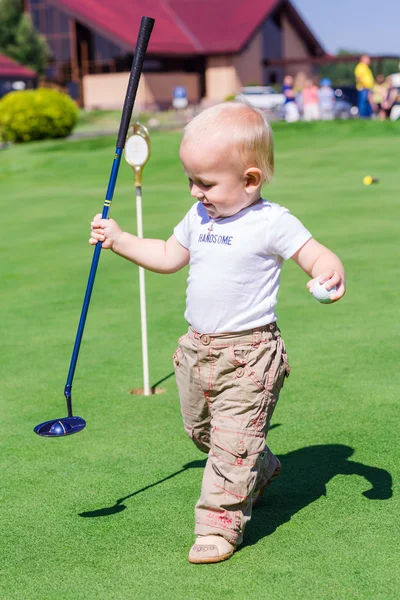 Cute little baby boy playing golf on a field — Stock Photo, Image