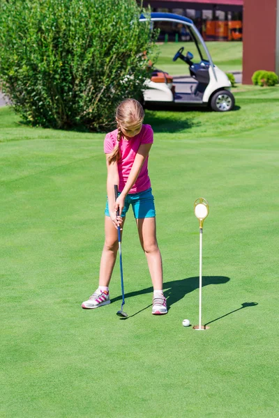 Schattig klein meisje golfen op een veld — Stockfoto