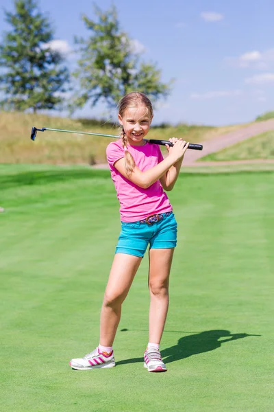 Schattig klein meisje golfen op een veld — Stockfoto