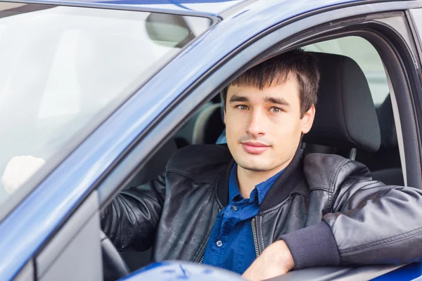 Красивый молодой человек сидит в своей машине — стоковое фото