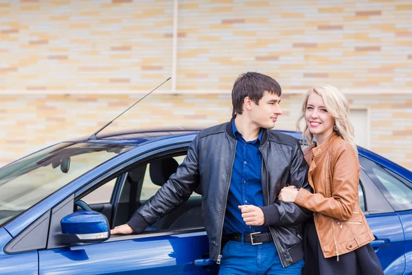 Счастливая молодая пара, стоящая возле машины — стоковое фото
