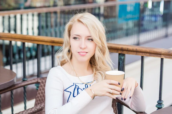 Beautiful young girl drinking coffe in a restaurant. — Stock Photo, Image