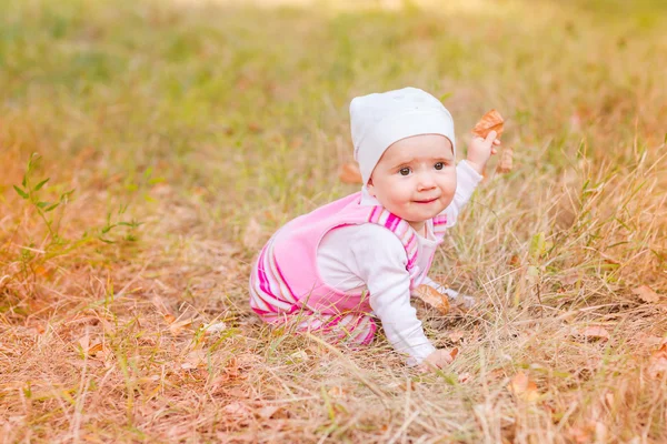 Söt baby flicka i höstlöv. — Stockfoto