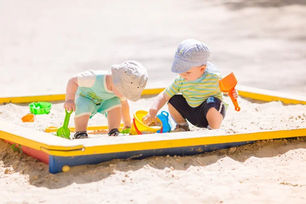 砂で遊ぶ 2 つの赤ちゃん男の子たち — ストック写真