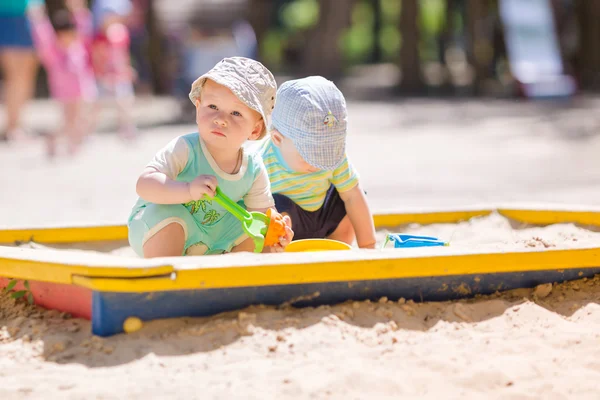 Deux bébés garçons jouant avec le sable — Photo