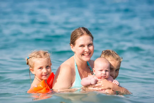 Madre feliz con los niños en el mar — Foto de Stock