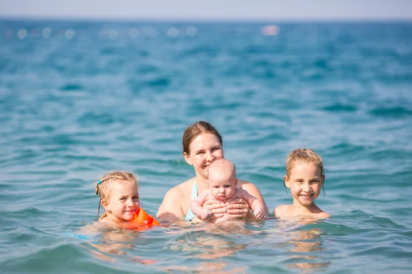 Gelukkig moeder met kinderen in de zee — Stockfoto