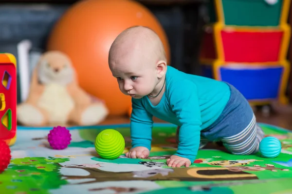 Niedliches kleines Baby spielt mit buntem Spielzeug — Stockfoto