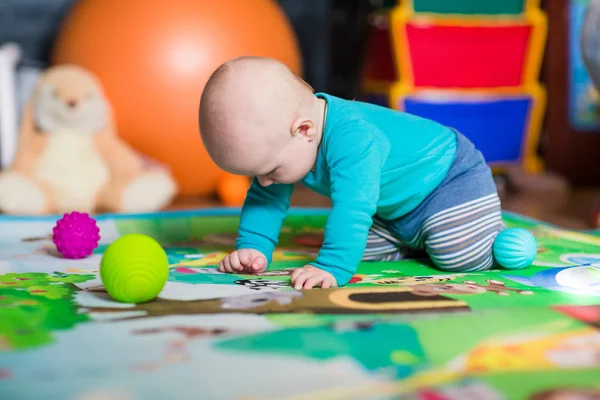 Schattige kleine baby spelen met kleurrijke speelgoed — Stockfoto