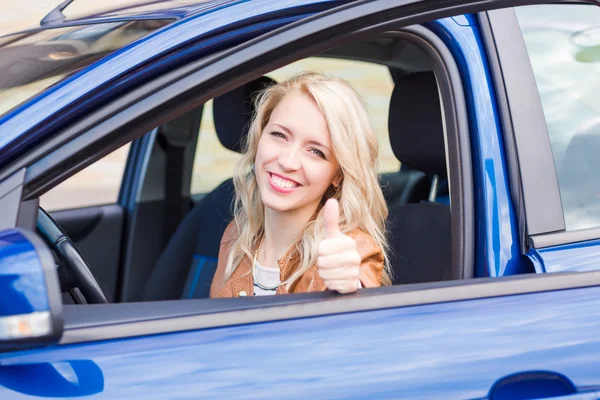 Hermosa joven feliz sentado en el coche — Foto de Stock