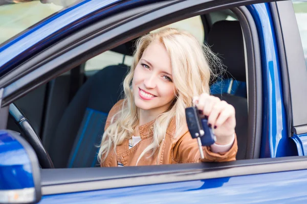 Belle jeune fille heureuse assise dans la voiture — Photo