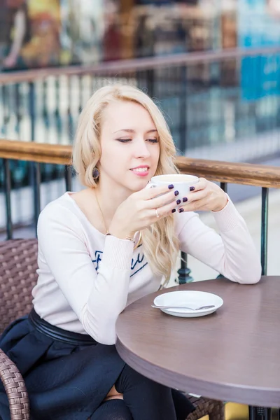 Schöne junge Mädchen trinkt Kaffee in einem Restaurant. — Stockfoto