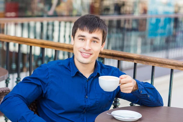 Schöner junger Mann trinkt Kaffee — Stockfoto