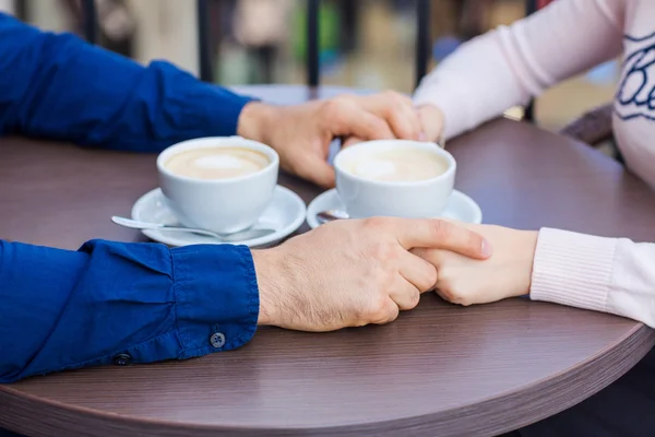 Handen van gelukkig verliefde paar in een restaurant — Stockfoto